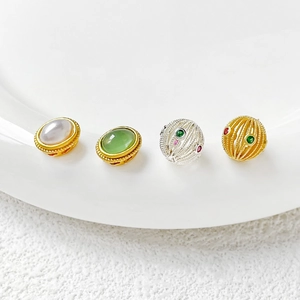 Detalle de cuentas vintage de oro y jade con intrincado diseño de jaula hueca para joyería DIY