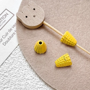 Macro detail of yellow waffle cone resin charms and wooden bear stick for DIY crafts