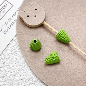 Macro detail of a green silicone protector with LOVE engraving on a wooden cat-shaped stand