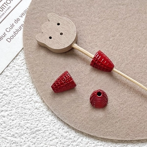 Detail of red conical DIY beads with LOVE engraving and wooden bear pin accessories
