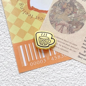 Close-up of yellow teacup-shaped resin bead with floral print for DIY jewelry making