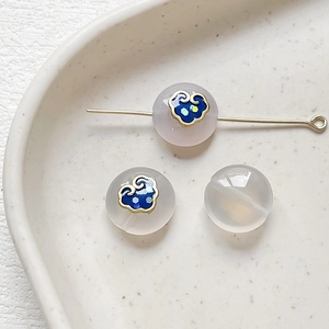 Macro shot of translucent agate beads with blue enamel auspicious cloud patterns and gold trim