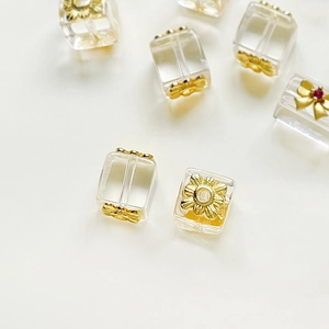 Gros plan de perles carrées en cristal avec fleurs dorées pour création de bijoux DIY