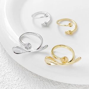 Detailed view of 18k gold and silver plated bow-shaped open ring bases with zircon accents