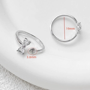 Macro detail of adjustable bow ring setting with zircon hearts and 3.8mm pearl base