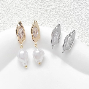 Detalle macro de pendientes de perlas barrocas chapados en oro de 18k con circonitas marquise