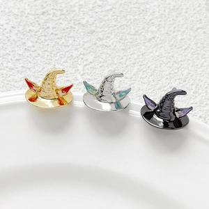 Detailed view of three enamel wizard hat pins in gold, silver, and black metal finishes