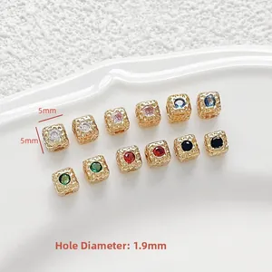 Macro view of 5mm 18k gold plated square spacer beads with zircon inlays and 1.9mm aperture