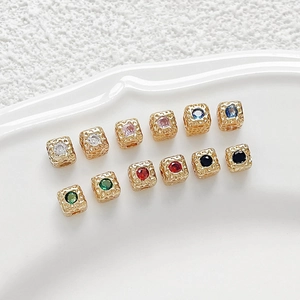 Detail macro of 18k gold-plated square cubic zirconia spacer beads with hammered texture