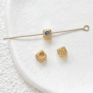 Macro shot of 18k gold plated square beads with blue zircon for DIY jewelry making
