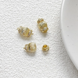 Macro shot of gold-plated lantern-shaped clasp with vertical stripes and zircon inlay