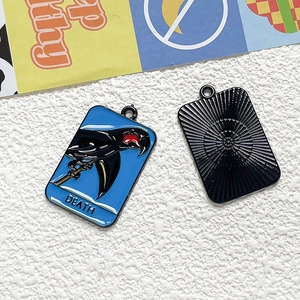 Macro detail of blue enamel parrot pendant with Death tarot motif and metallic back