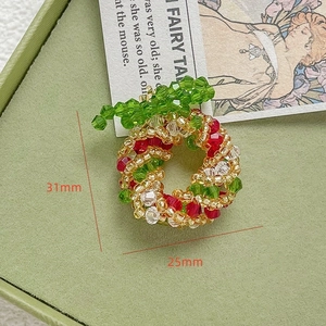 Dettaglio di un ciondolo a ghirlanda natalizia in perline fatto a mano 31mm x 25mm