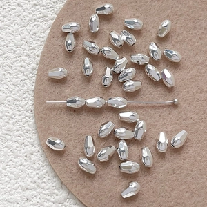 Macro detail of faceted silver metal beads with central hole for DIY jewelry making