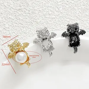 Macro detail of gold and silver dragon charms with an 8mm pearl inlay for jewelry making