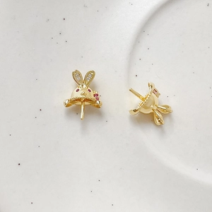 Detailed view of gold rabbit ear charms with red crystals and white cubic zirconia accents