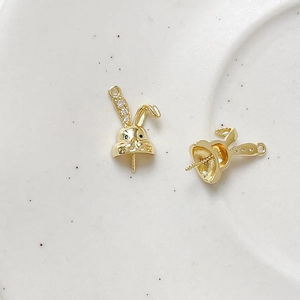 Detailed view of gold rabbit ear pearl pegs with sparkling zircon accents for DIY jewelry