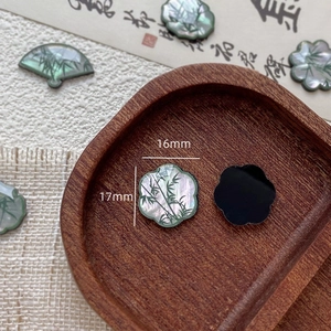 Macro detail of mother-of-pearl shell charms with green bamboo ink painting