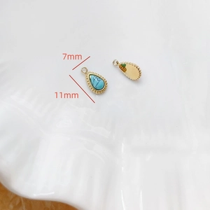 Détail du pendentif goutte turquoise 7x11mm avec base en métal doré sur plat blanc