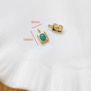 Détail d'un pendentif rectangulaire plaqué or avec pierre turquoise, dimensions 14mm
