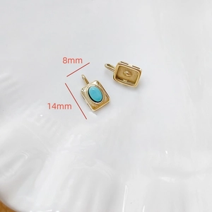 Détail d'un pendentif rectangulaire doré 14x8mm serti d'une pierre turquoise bleue brillante