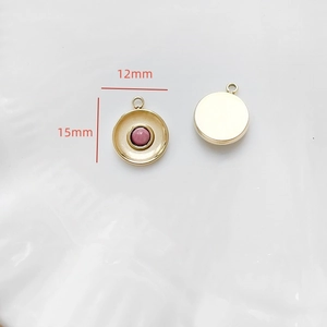 Détail d'un pendentif rond de 12mm en pierre rose avec cadre en acier plaqué or