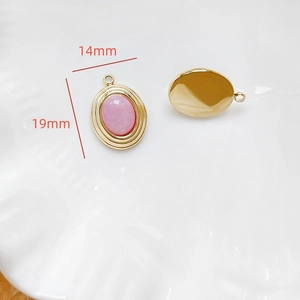 Détail d'un pendentif ovale doré 14x19mm avec pierre rose pour bijoux DIY