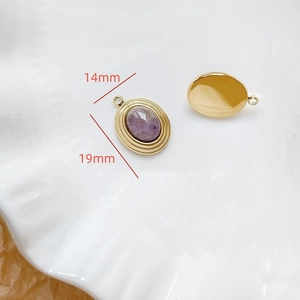 Vue macro de pendentifs ovales en pierre précieuse dorés 14mmx19mm sur un plateau