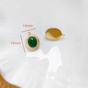 Vue macro du pendentif ovale serti d'une pierre verte de 19x14mm avec monture dorée