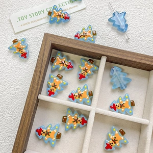 Macro detail of blue Christmas tree glass beads with gingerbread man patterns for DIY jewelry