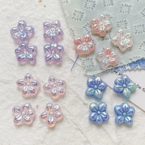Flat lay of iridescent five-petal flower resin charms in pastel colors for DIY jewelry