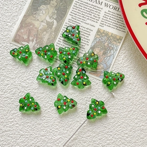 Makro-Detail von grünen Weihnachtsbaum-Glasperlen mit bunten handgemalten Punkten für DIY