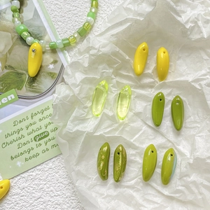 Macro detail of oval mini banana glass beads in various green and yellow shades for DIY