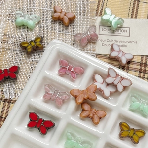 Colorful Czech glass butterfly beads in ceramic tray for DIY jewelry making and crafts