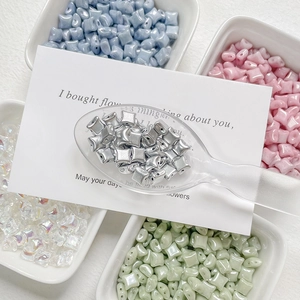Colorful star-shaped Czech glass beads for DIY jewelry making in a white ceramic tray