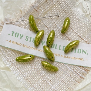 Macro detail of green and gold foil glass banana beads for DIY jewelry making