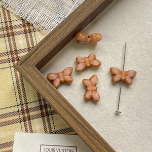 Macro detail of butterfly glass beads in warm orange for DIY jewelry making and crafts