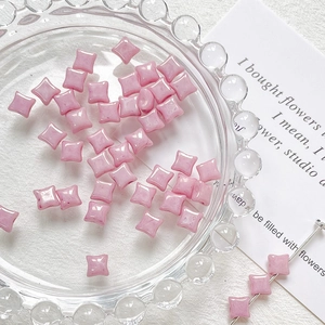Close-up of pink star-shaped glass beads for DIY jewelry making and handmade crafts