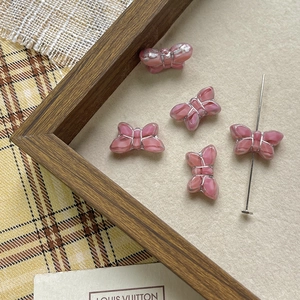 Detailed view of pink translucent butterfly beads with silver outlines for DIY jewelry