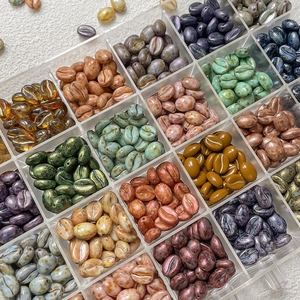 Assorted coffee bean shape beads for DIY jewelry in a clear compartmentalized box