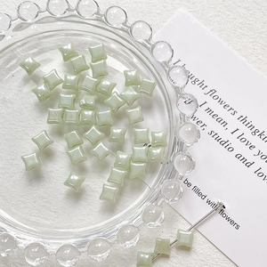 Macro detail of mint green square Czech glass beads with pearlescent finish for DIY jewelry
