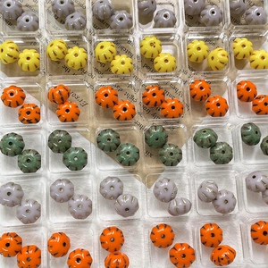 Colorful pumpkin shaped glass beads for DIY jewelry making in a transparent organizer box