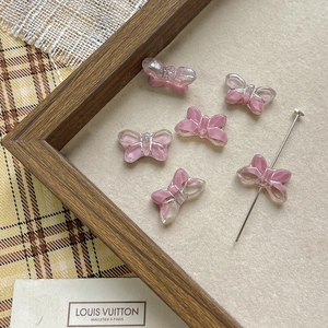 Detailed view of pink butterfly glass beads for DIY jewelry with metal threading pin