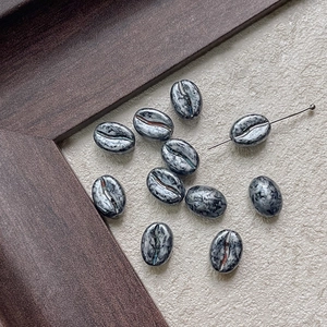 Macro shot of marble textured coffee bean shaped beads for DIY jewelry making and crafts