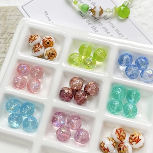 Assorted colorful glass beads for DIY jewelry displayed in a white ceramic tray