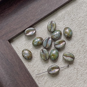 Macro detail of coffee bean shaped glass beads with a metallic reactive glaze finish