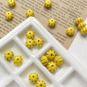 Macro detail of yellow pumpkin Czech glass beads with vintage textured stripes for DIY jewelry