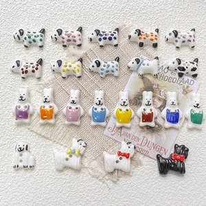 Detailed view of hand-painted ceramic rabbit and dog buttons with two holes for DIY jewelry