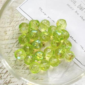 Macro shot of grass green Czech glass beads with irregular faceted cut and AB coating