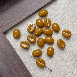 Macro detail of coffee bean glass beads with gold crackle texture and functional drill hole